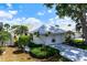 Charming one-story home featuring a white tiled roof, well-manicured landscaping, and attached two-car garage at 799 Harrington Lake N Dr # 73, Venice, FL 34293