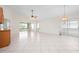 Spacious living area with tile flooring, large windows, a ceiling fan, and access to a sunroom at 799 Harrington Lake N Dr # 73, Venice, FL 34293