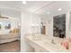 Bright bathroom with a mirrored vanity, walk-in closet and view into the bedroom at 810 Capri Isles Blvd # 230, Venice, FL 34292