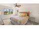 Comfortable bedroom with neutral tones, ceiling fan, and windows overlooking the grounds at 810 Capri Isles Blvd # 230, Venice, FL 34292