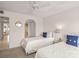Neutral bedroom with twin beds, carpet, and a view of other rooms at 810 Capri Isles Blvd # 230, Venice, FL 34292