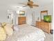 Bedroom with a ceiling fan, dresser, and ensuite bathroom at 810 Capri Isles Blvd # 230, Venice, FL 34292