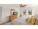Cozy bedroom with a ceiling fan, dresser with tv and views of the property at 810 Capri Isles Blvd # 230, Venice, FL 34292