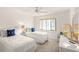 Bright bedroom featuring two twin beds, neutral walls, and a large window providing plenty of natural light at 810 Capri Isles Blvd # 230, Venice, FL 34292