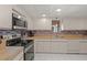 Well-lit kitchen with wood counters, a range of modern appliances, and white cabinets at 810 Capri Isles Blvd # 230, Venice, FL 34292