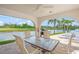 Inviting covered patio with golf course views, comfortable seating, grill, and ceiling fan for outdoor relaxation at 810 Capri Isles Blvd # 230, Venice, FL 34292