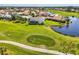 An aerial view of the property with a golf course, a lake, and some homes in the neighborhood at 854 Blue Crane Dr, Venice, FL 34285