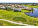 An aerial view of the property with a golf course, a lake, and some homes in the neighborhood at 854 Blue Crane Dr, Venice, FL 34285