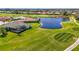 Aerial view of the property and surrounding golf course community with a lake at 854 Blue Crane Dr, Venice, FL 34285