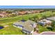 Beautiful home with a green roof, well-maintained yard, mature trees, and a view of the golf course at 854 Blue Crane Dr, Venice, FL 34285