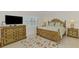 A bedroom with a flat screen tv and a decorative bedspread at 854 Blue Crane Dr, Venice, FL 34285