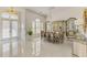Elegant dining room with a large chandelier, mirrored accents, and gleaming tile floors next to front door at 854 Blue Crane Dr, Venice, FL 34285
