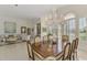 Elegant dining room with chandelier, open layout, and view into the living room at 854 Blue Crane Dr, Venice, FL 34285