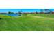 Scenic view of a well-maintained golf course with a pond, surrounded by beautiful homes under a clear blue sky at 854 Blue Crane Dr, Venice, FL 34285