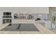 Gourmet kitchen with stainless steel appliances, granite countertops, custom cabinetry, and cooktop island with downdraft at 854 Blue Crane Dr, Venice, FL 34285