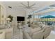 Open-concept living room with a sleek ceiling fan, large windows, and access to outdoor patio at 854 Blue Crane Dr, Venice, FL 34285
