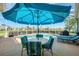 Charming poolside seating area under a large umbrella with views of the golf course at 854 Blue Crane Dr, Venice, FL 34285