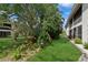 Well-maintained backyard featuring lush landscaping and mature trees at 930 Capri Isles Blvd # 120, Venice, FL 34292