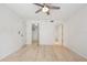 Bright bedroom featuring wood-look floors, ceiling fan, and closet and bathroom access at 930 Capri Isles Blvd # 120, Venice, FL 34292