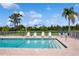 Community pool with chairs and lush landscaping at 930 Capri Isles Blvd # 120, Venice, FL 34292