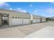 Exterior view of multiple garages featuring white doors and matching roof in a sunny neighborhood at 930 Capri Isles Blvd # 120, Venice, FL 34292