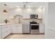 Updated kitchen featuring stainless appliances, white cabinetry and stone backsplash at 930 Capri Isles Blvd # 120, Venice, FL 34292