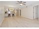 Bright living room with wood-look floors and a modern light fixture above the kitchen bar at 930 Capri Isles Blvd # 120, Venice, FL 34292
