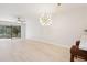 Bright living room with wood-look floors and sliding glass doors leading to a screened-in lanai at 930 Capri Isles Blvd # 120, Venice, FL 34292