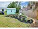 Well-maintained yard with a shed, vibrant flower bed, and various equipment at 990 Sea Fox Rd, Venice, FL 34293