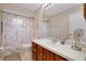 Bathroom featuring vanity with a white countertop and wood cabinetry, a toilet, and a shower with a curtain at 990 Sea Fox Rd, Venice, FL 34293