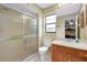 Bathroom featuring a walk-in shower, toilet, and vanity with a white countertop and wood cabinetry at 990 Sea Fox Rd, Venice, FL 34293