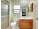 Bathroom featuring a walk-in shower, toilet, and vanity with a white countertop and wood cabinetry at 990 Sea Fox Rd, Venice, FL 34293