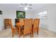Dining area featuring a wood table, seating for six, a ceiling fan, and plantation shutters for natural light at 990 Sea Fox Rd, Venice, FL 34293