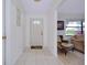 Bright entryway with tile flooring, a white front door, and a view into the adjacent living area at 990 Sea Fox Rd, Venice, FL 34293
