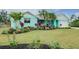 Charming single-story home with colorful landscaping, palm trees, and an attached two-car garage at 990 Sea Fox Rd, Venice, FL 34293