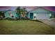Charming single-story home with colorful landscaping, palm trees, and an attached two-car garage at dusk at 990 Sea Fox Rd, Venice, FL 34293