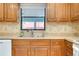 Close-up of the kitchen sink area with wood cabinets, a window view, and ample counter space at 990 Sea Fox Rd, Venice, FL 34293