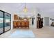 Bright and airy living area with wood floors, chandelier, and access to the sunroom and kitchen at 990 Sea Fox Rd, Venice, FL 34293