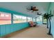 Relaxing sunroom with multiple ceiling fans, bright walls, and a comfortable wicker sofa at 990 Sea Fox Rd, Venice, FL 34293