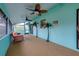 Bright sunroom with bright blue trim, ceiling fans, and decorative palm trees at 990 Sea Fox Rd, Venice, FL 34293