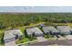 Aerial view of homes with tile roofs and a pond surrounded by lush greenery, offering a serene and picturesque setting at 10136 Coral Shore Dr, Englewood, FL 34223