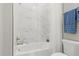 Bright bathroom features marble-look tile, a bathtub and shower combination with brushed nickel fixtures at 10136 Coral Shore Dr, Englewood, FL 34223