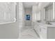 Modern bathroom features a walk-in shower with marble tile and double sink vanity at 10136 Coral Shore Dr, Englewood, FL 34223