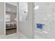 Bathroom featuring a walk-in shower with glass doors and access to the bedroom at 10136 Coral Shore Dr, Englewood, FL 34223