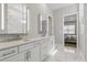 Bathroom with double sink vanity, marble countertops, and access to the bedroom at 10136 Coral Shore Dr, Englewood, FL 34223