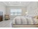 Brightly illuminated bedroom, with a gray color palette, features wide windows and a ceiling fan at 10136 Coral Shore Dr, Englewood, FL 34223