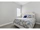 A tranquil bedroom with a tufted headboard and light gray wood flooring at 10136 Coral Shore Dr, Englewood, FL 34223