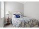 Bright bedroom with bedside table, a tufted headboard and gray wood flooring at 10136 Coral Shore Dr, Englewood, FL 34223