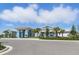 Exterior shot of the Beachwalk clubhouse featuring blue and white accents with lush landscaping at 10136 Coral Shore Dr, Englewood, FL 34223