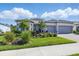 Charming single-story home with a gray tile roof, lush landscaping, and a spacious driveway at 10136 Coral Shore Dr, Englewood, FL 34223
